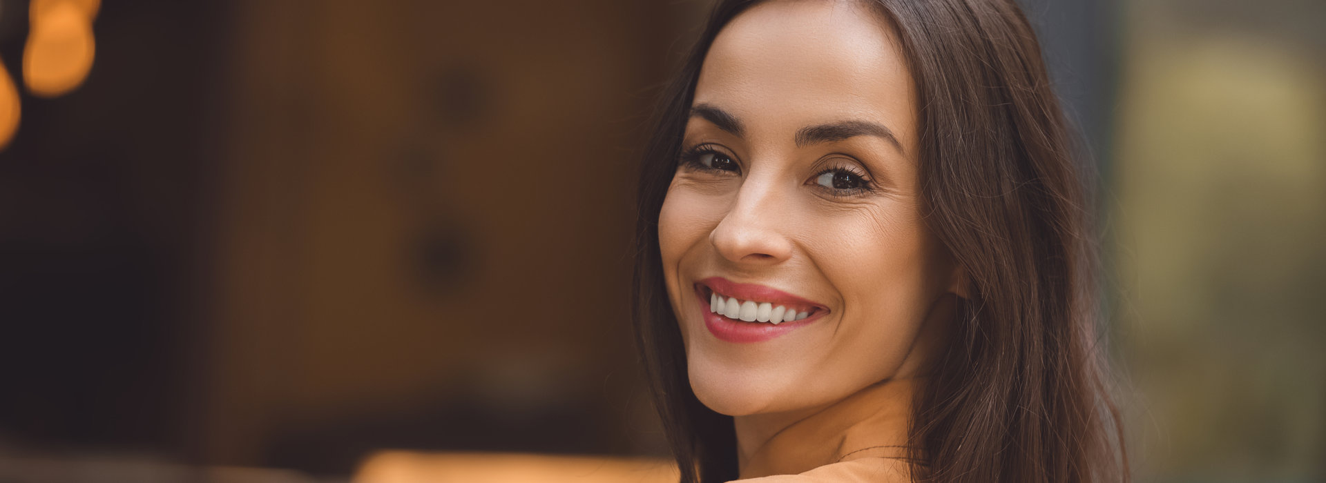 A woman is smiling after orthodontic appliances.